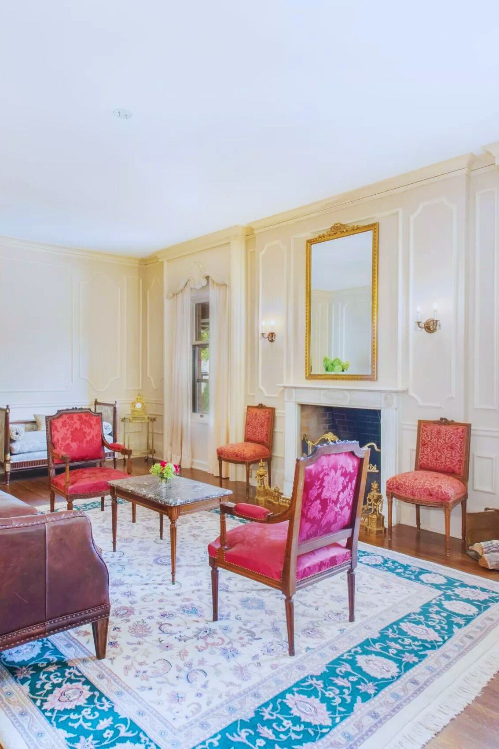 elegant living room with antique chairs, fireplace, and gold-framed mirror at Martha’s Bed and Breakfast in Lincoln, Nebraska