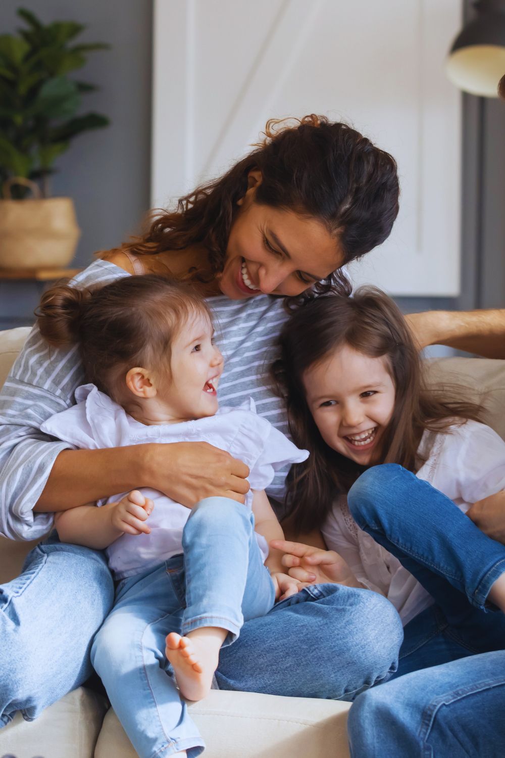 Mother with two young daughters laughing together in a cozy family-friendly room at Martha's Bed and Breakfast in Lincoln, Nebraska